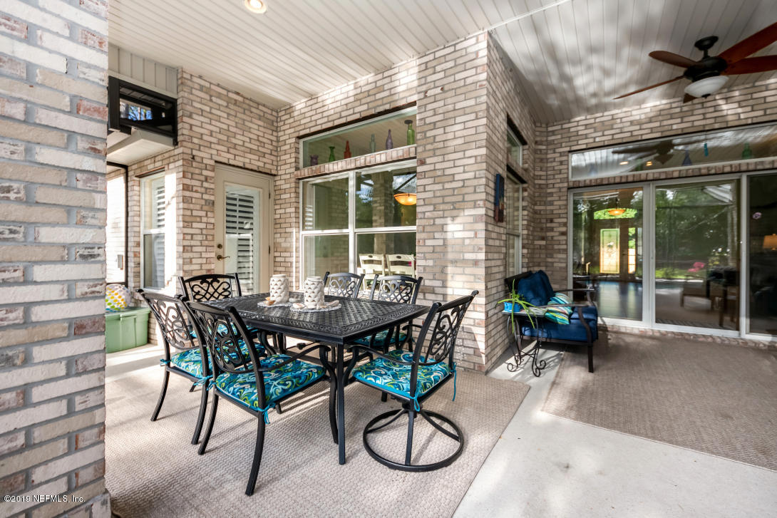 87465 Creekside Drive Yulee, FL 32097 - Photo 27 of 40 a view of a patio with table and chairs and potted plants