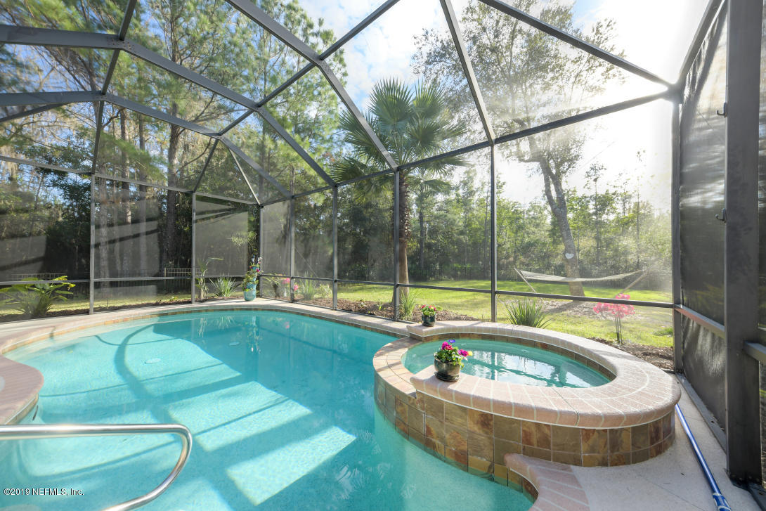 87465 Creekside Drive Yulee, FL 32097 - Photo 28 of 40 a swimming pool with outdoor seating and yard