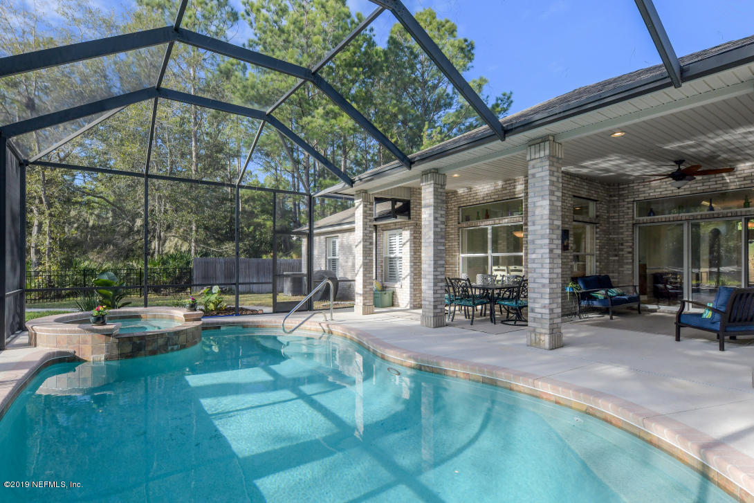 87465 Creekside Drive Yulee, FL 32097 - Photo 29 of 40 a swimming pool with outdoor seating and yard