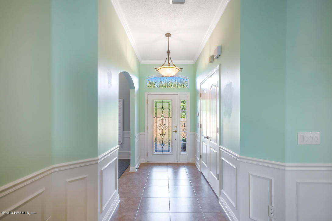 87465 Creekside Drive Yulee, FL 32097 - Photo 10 of 40 a view of a hallway with chandelier and stairs