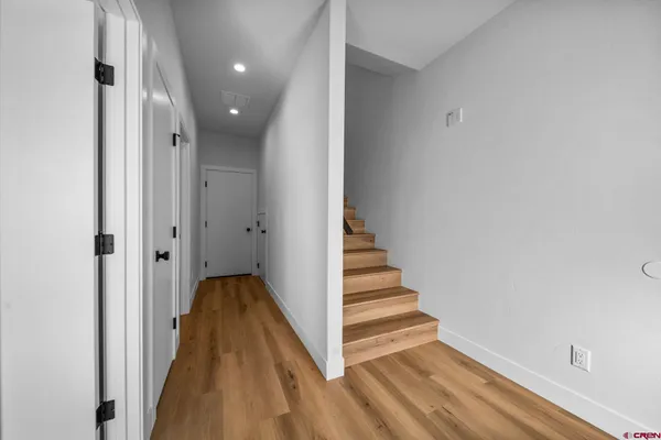a view of a hallway with wooden floor and entryway