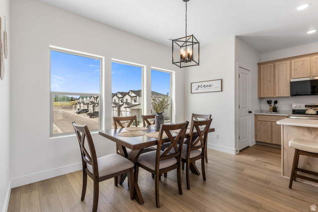 636 West Caroles Way, Unit 7 Tooele, UT 84074 - Photo 8 of 31 Open-concept dining area featuring a wood-finish floor and a modern geometric chandelier
