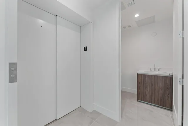 a kitchen with white cabinets and window