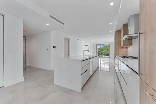 a kitchen with stainless steel appliances granite countertop a stove a sink and a refrigerator