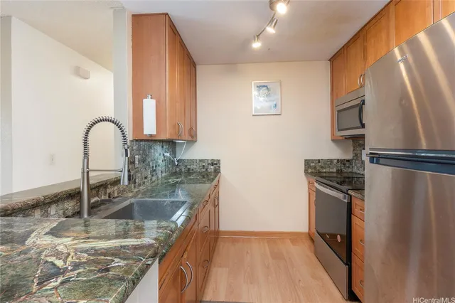 a kitchen with kitchen island granite countertop a sink stove and refrigerator