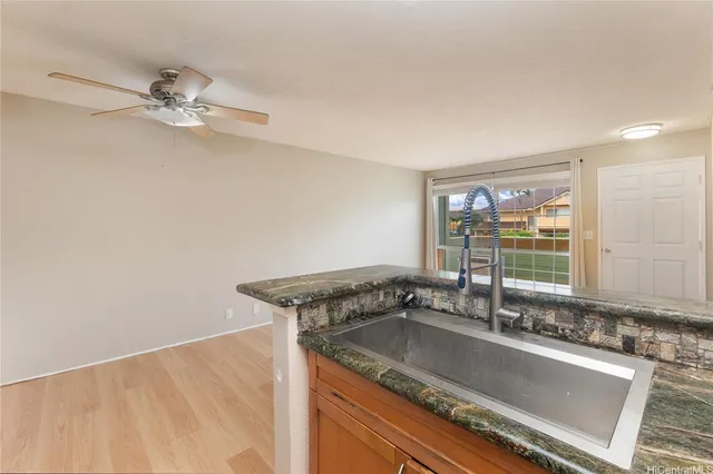 a bathroom with a granite countertop sink and a window