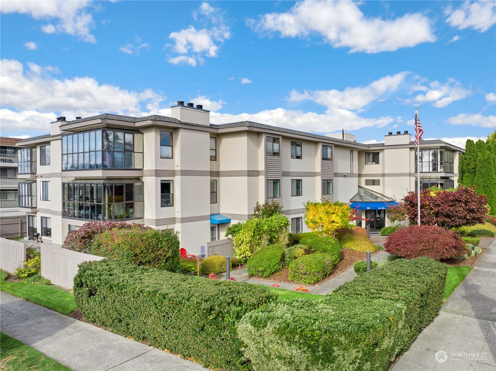 201 3rd Avenue North, Unit 102 Edmonds, WA 98020 - Photo 1 of 39 a view of a white building among the yard and potted plants