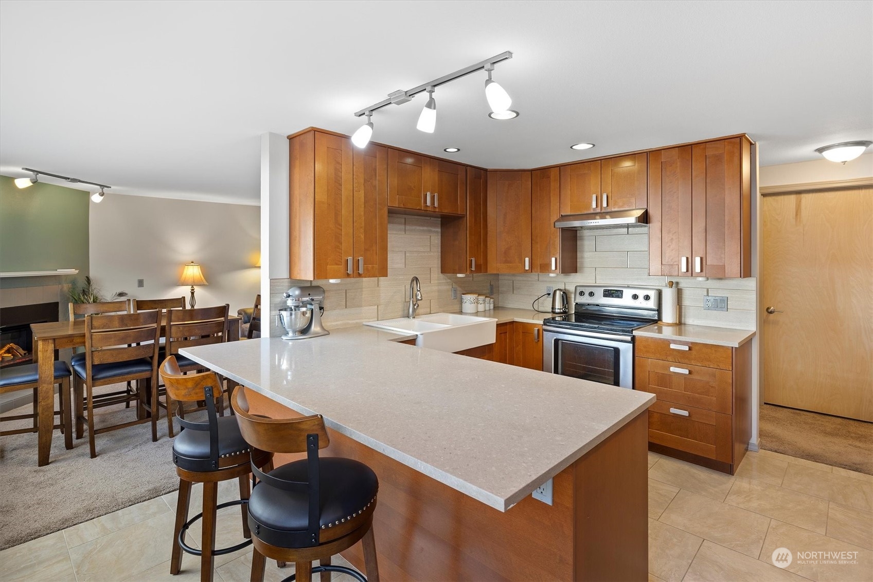 201 3rd Avenue North, Unit 102 Edmonds, WA 98020 - Photo 11 of 39 a large kitchen with kitchen island a stove a sink a dining table and chairs