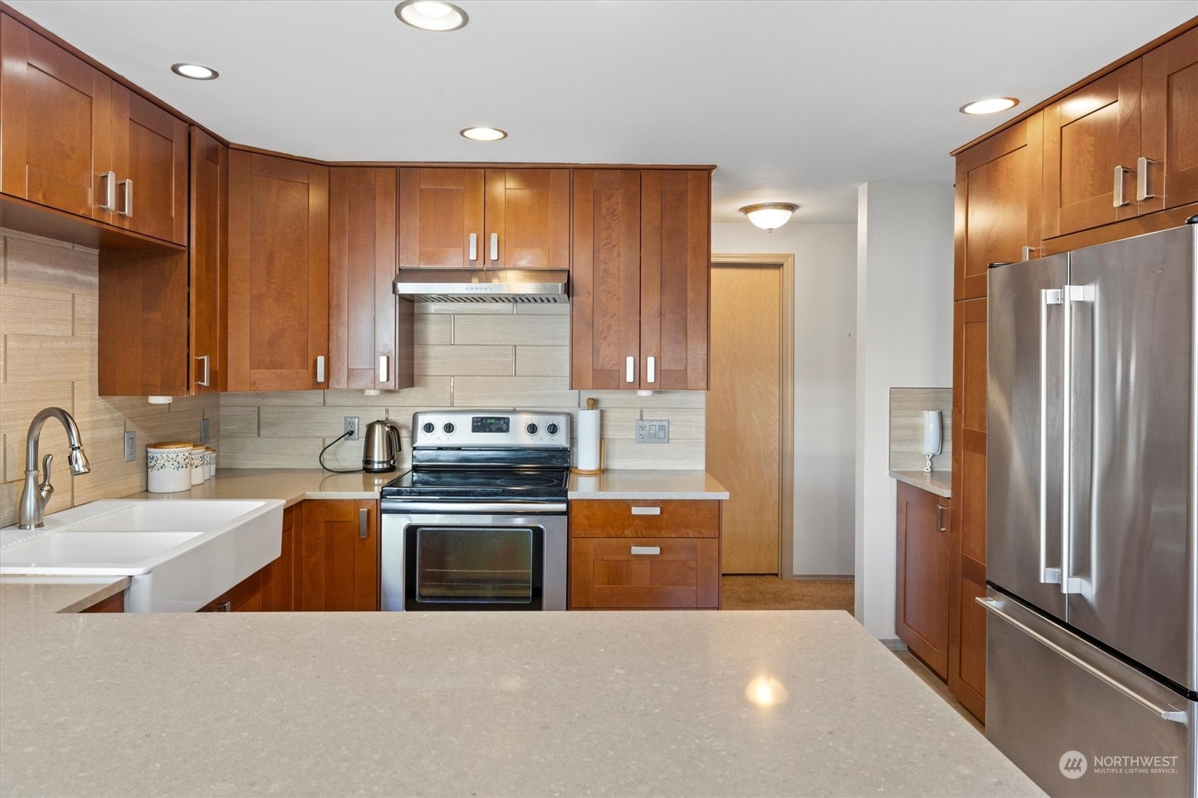 201 3rd Avenue North, Unit 102 Edmonds, WA 98020 - Photo 15 of 39 a kitchen with stainless steel appliances granite countertop a refrigerator a sink dishwasher a stove and a refrigerator with wooden cabinets