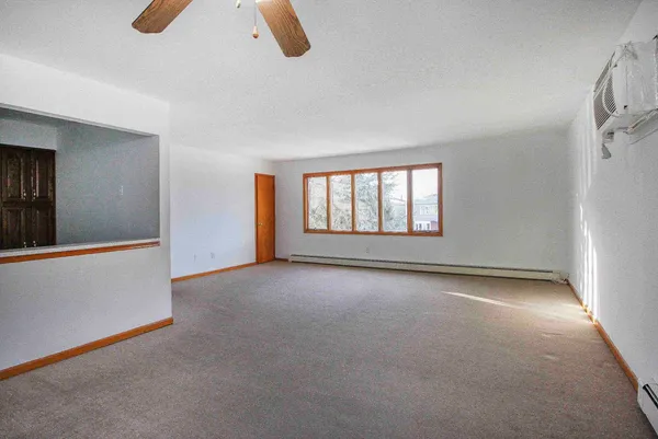 an empty room with windows and fan
