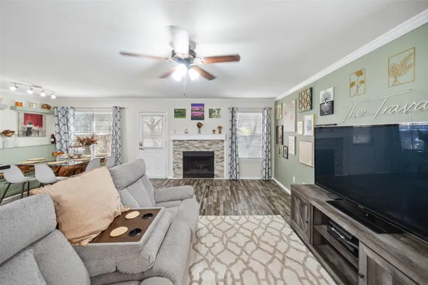 a living room with furniture a flat screen tv and a fireplace