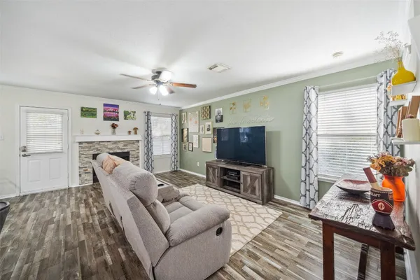a living room with furniture a flat screen tv and a window