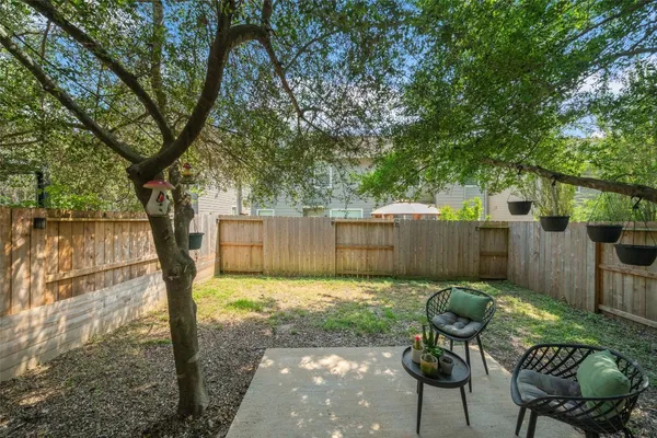 a view of a backyard with a large tree and wooden fence