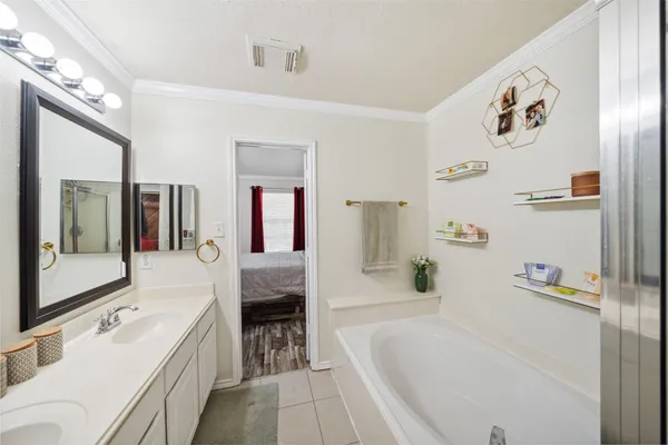 a bathroom with a tub a sink and mirror