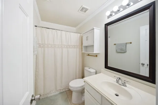 a bathroom with a sink vanity mirror and toilet