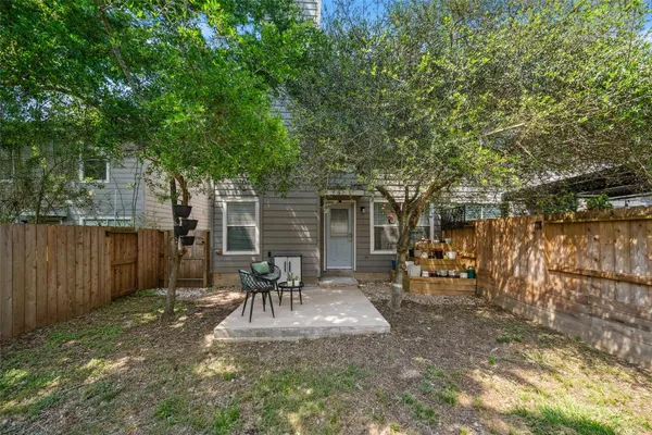 a view of a backyard with table and chairs and wooden fence