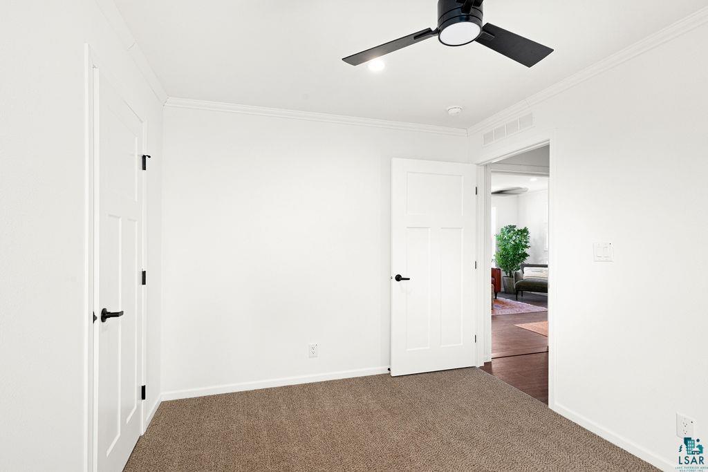 415 Cumming Avenue Superior, WI 54880 - Photo 14 of 26 Unfurnished bedroom with ornamental molding, dark colored carpet, and ceiling fan