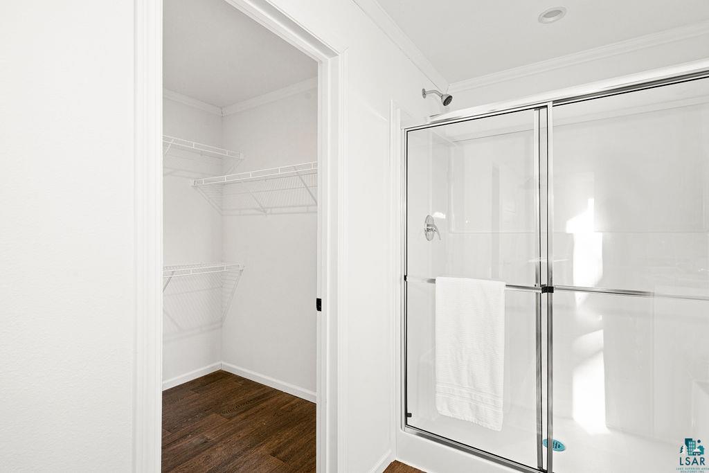 415 Cumming Avenue Superior, WI 54880 - Photo 20 of 26 Full bath with a stall shower, ornamental molding, dark wood-style floors, and a walk in closet