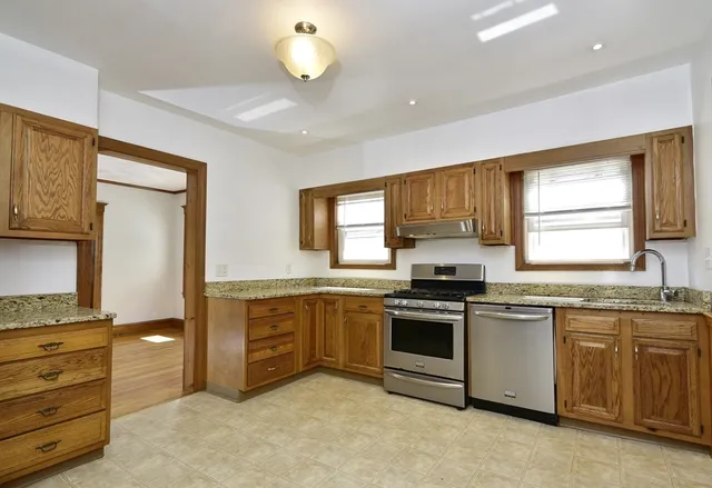 a kitchen with stainless steel appliances granite countertop a stove and a sink