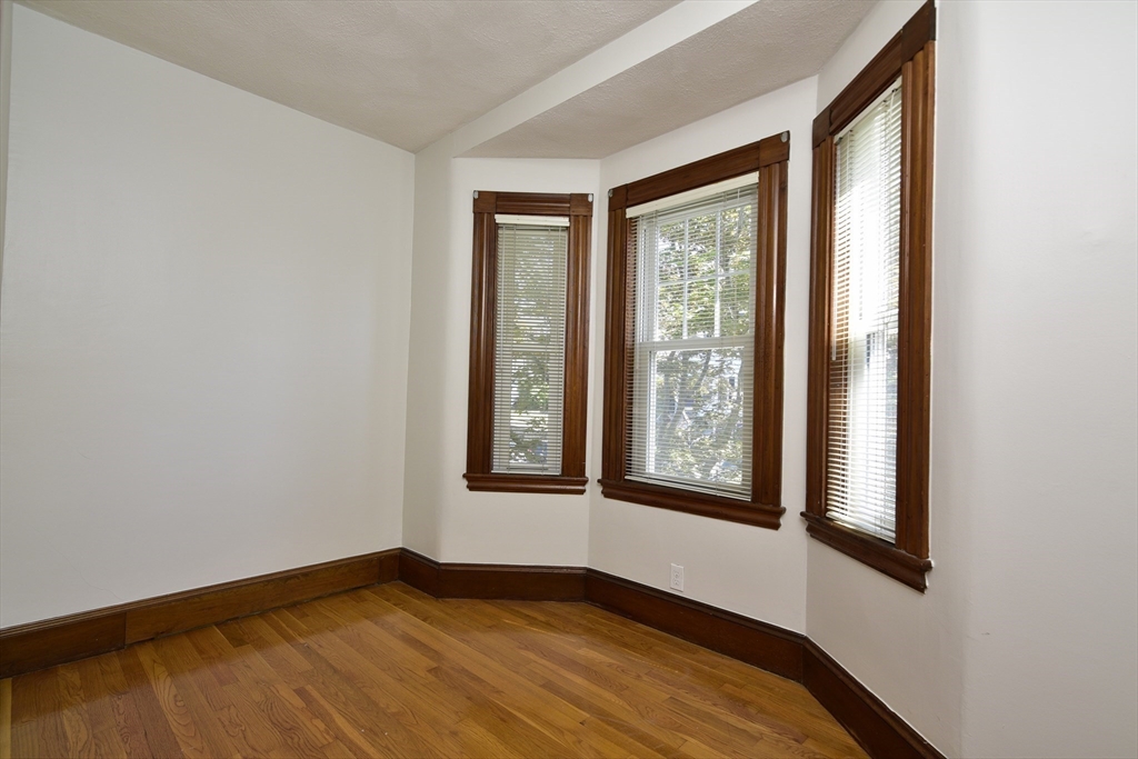 43 Oakridge Street, Unit 2 Boston, MA 02126 - Photo 7 of 8 a view of an empty room with wooden floor and a window