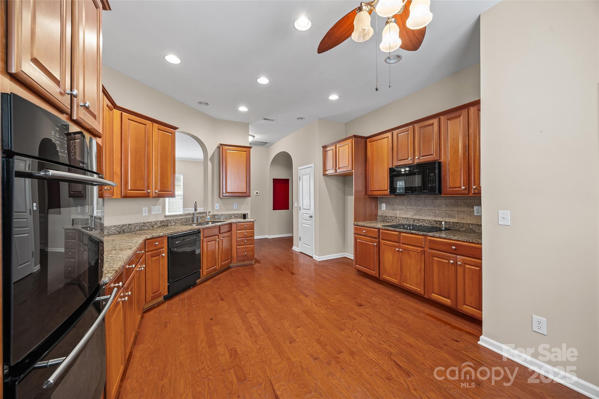 1033 Knob Creek Lane Tega Cay, SC 29708 - Photo 14 of 45 a large kitchen with stainless steel appliances granite countertop a refrigerator a stove and a sink with wooden floor