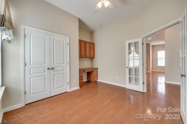 an empty room with windows cabinet and fire place