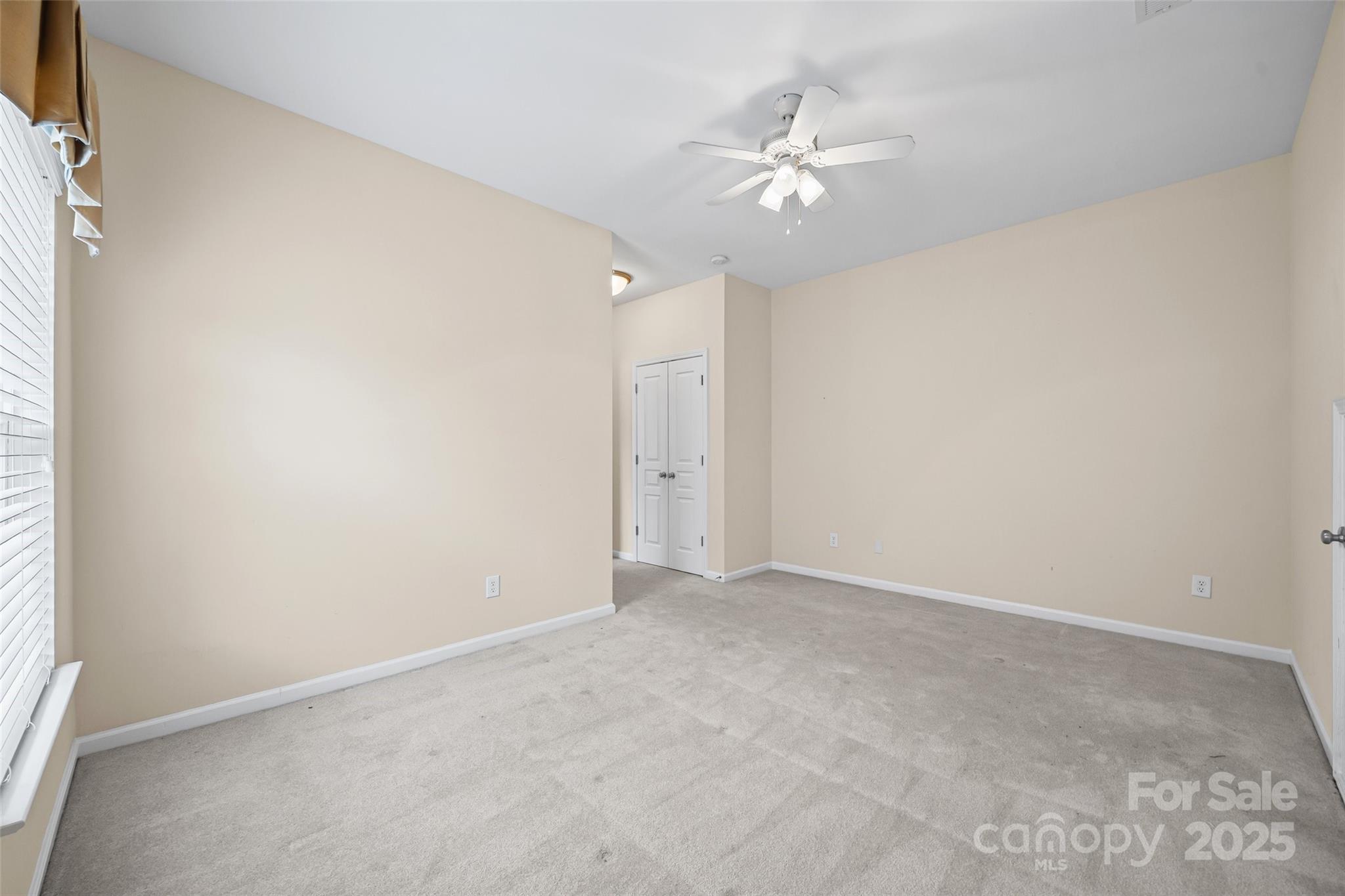1033 Knob Creek Lane Tega Cay, SC 29708 - Photo 35 of 45 an empty room with a chandelier fan and windows