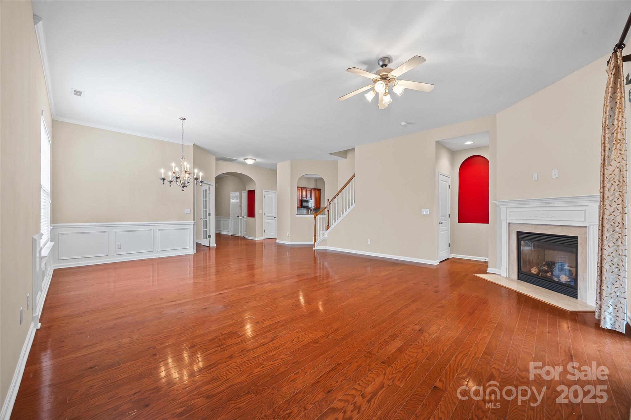 1033 Knob Creek Lane Tega Cay, SC 29708 - Photo 7 of 45 a view of a livingroom with a fireplace a chandelier and wooden floor