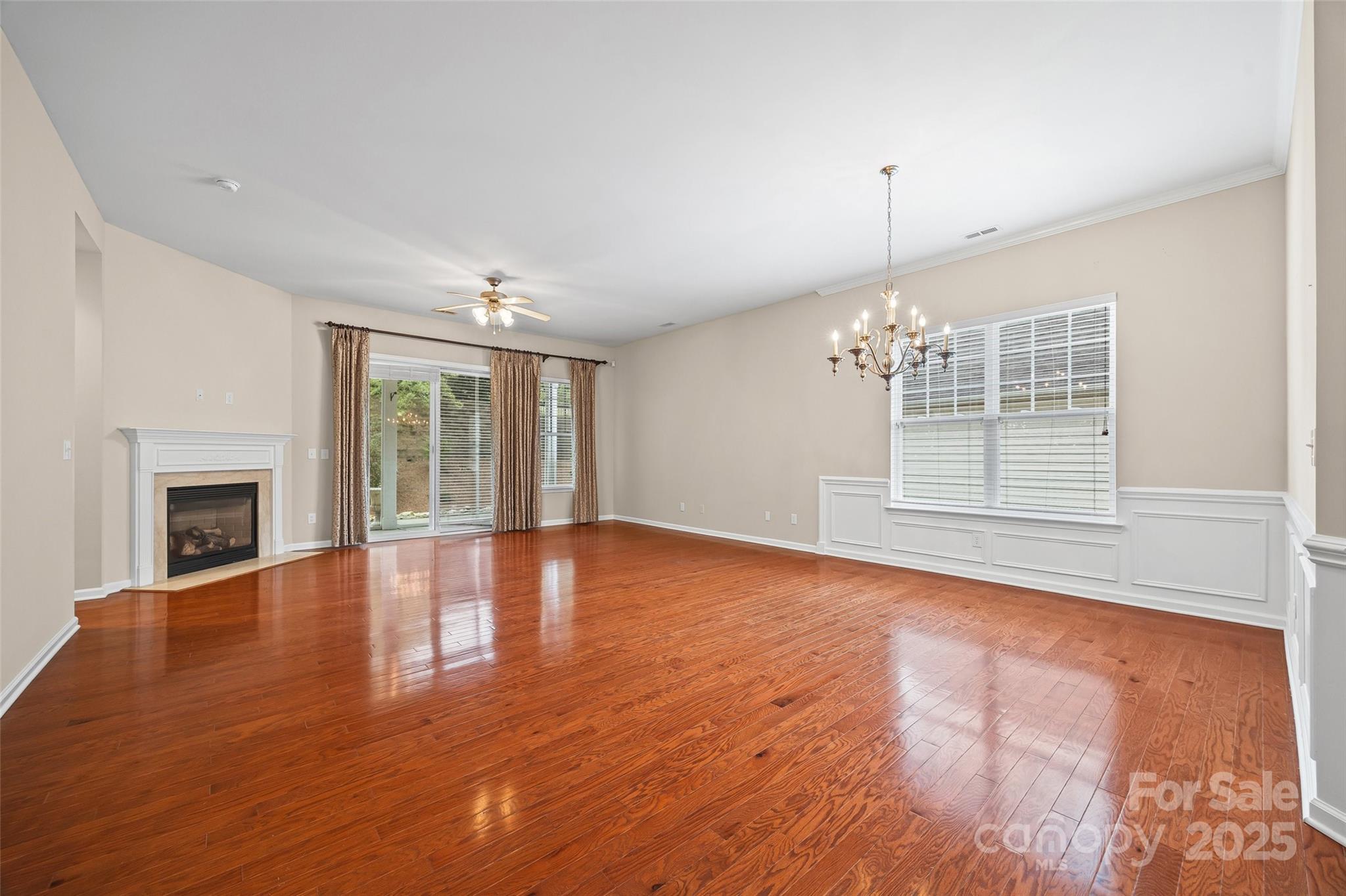 1033 Knob Creek Lane Tega Cay, SC 29708 - Photo 10 of 45 an empty room with wooden floor fireplace and windows