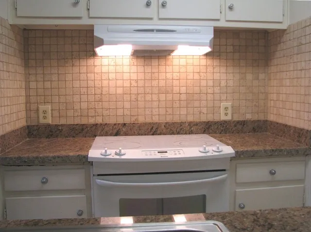 a bathroom with a granite countertop sink a toilet and shower