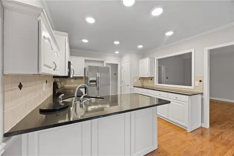 a kitchen with stainless steel appliances granite countertop a sink a stove and a refrigerator
