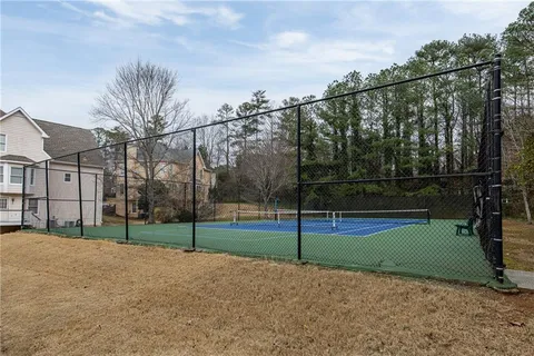 a view of house with yard and trees in the background