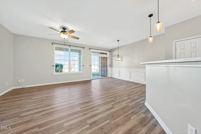 a view of a kitchen with wooden floor and a ceiling fan
