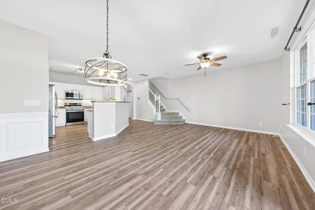 a kitchen with stainless steel appliances granite countertop a sink a stove and cabinets with wooden floor