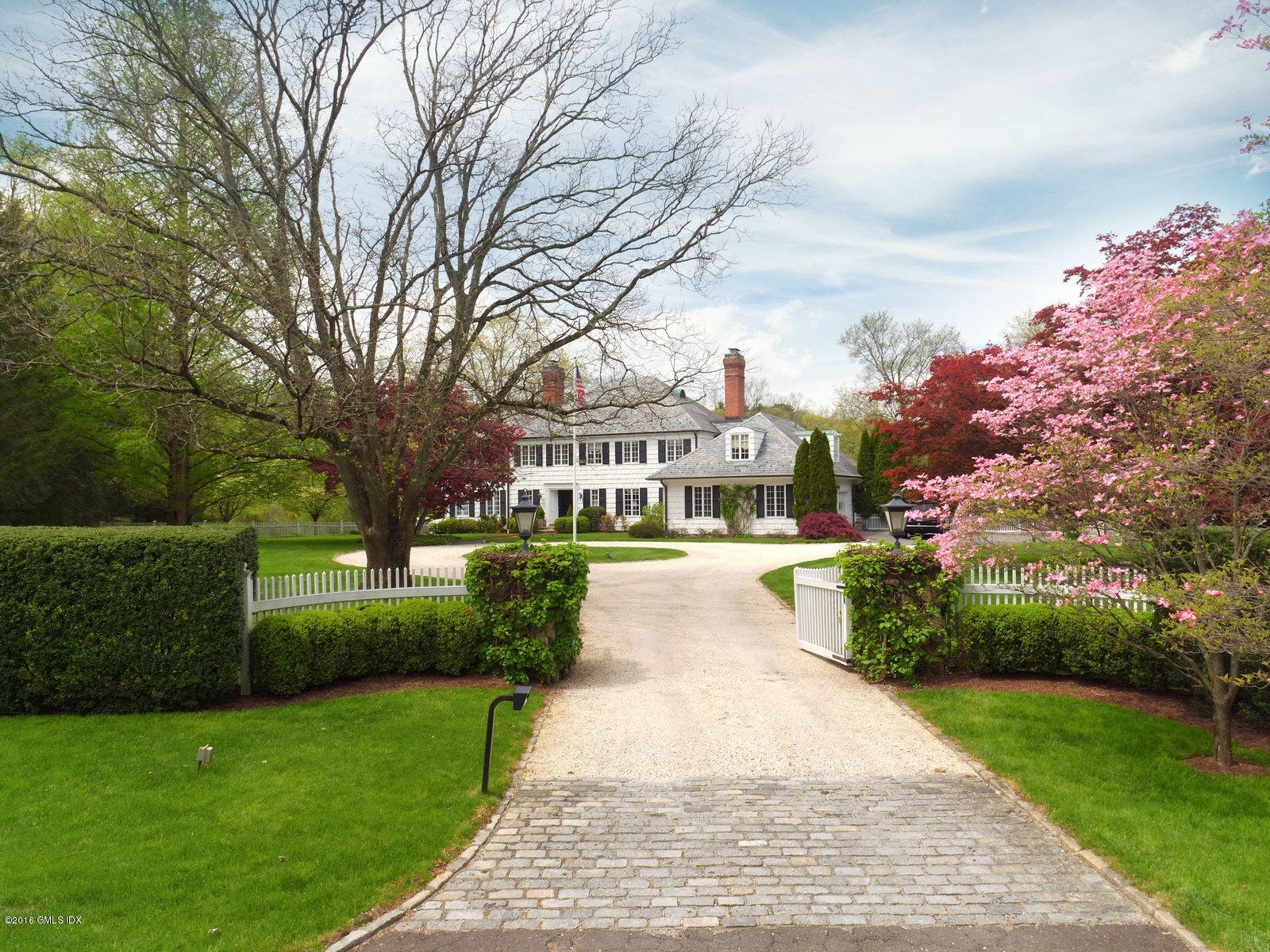 29 Lindsay Drive Greenwich, CT 06830 - Photo 2 of 17 a front view of a house with a garden and fountain