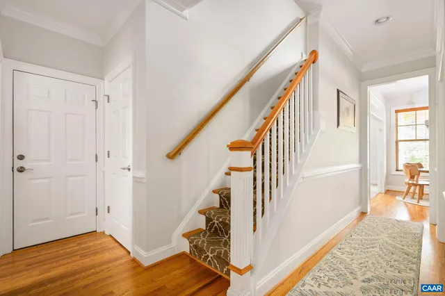 a view of a hallway with wooden floor and staircase