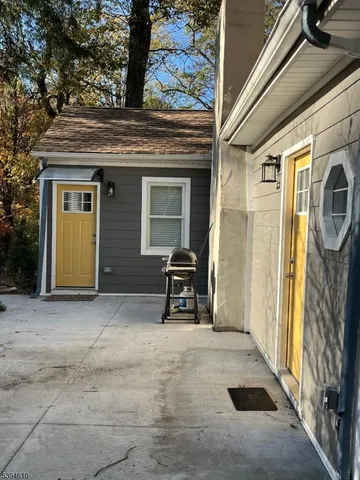 a backyard of a house with barbeque oven table and chairs