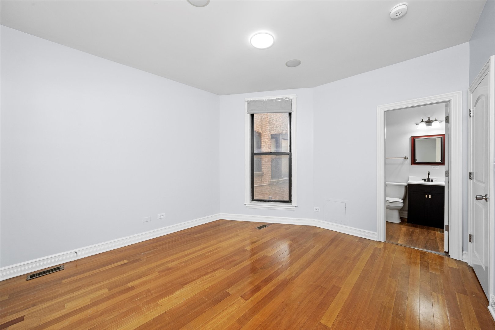 1363 East 64th Street, Unit 1 Chicago, IL 60637 - Photo 11 of 39 wooden floor in an empty room with a window