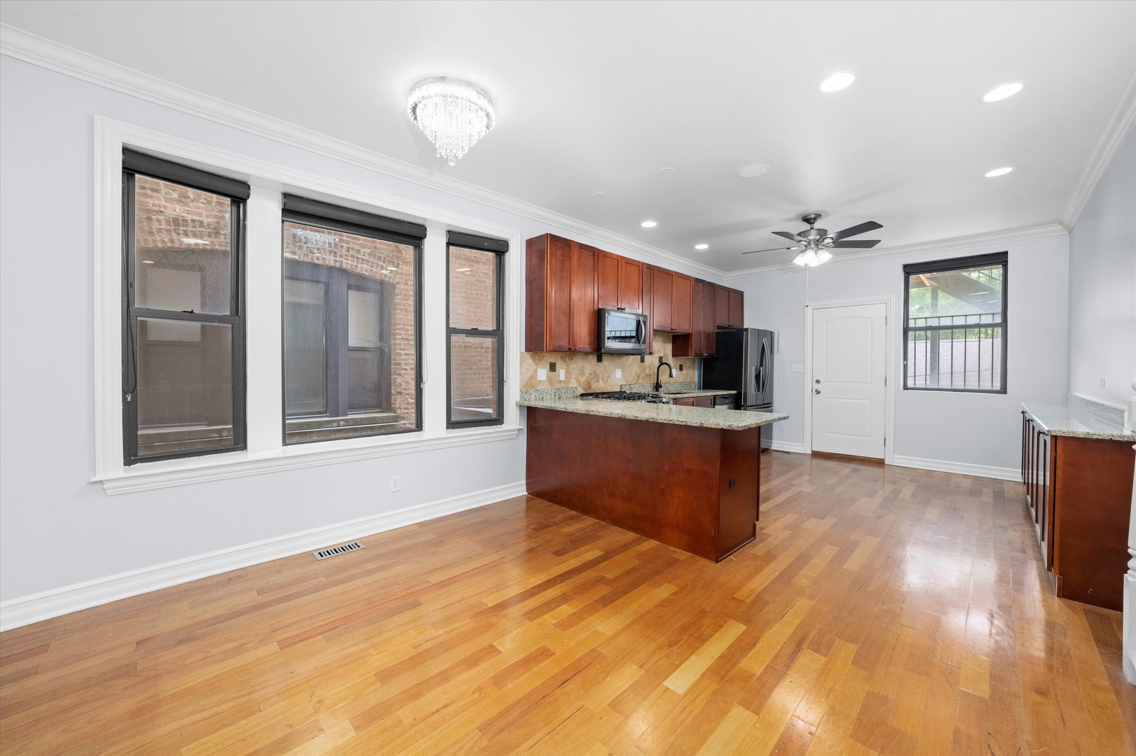 1363 East 64th Street, Unit 1 Chicago, IL 60637 - Photo 14 of 39 a large kitchen with stainless steel appliances kitchen island a large counter top and a wooden floors