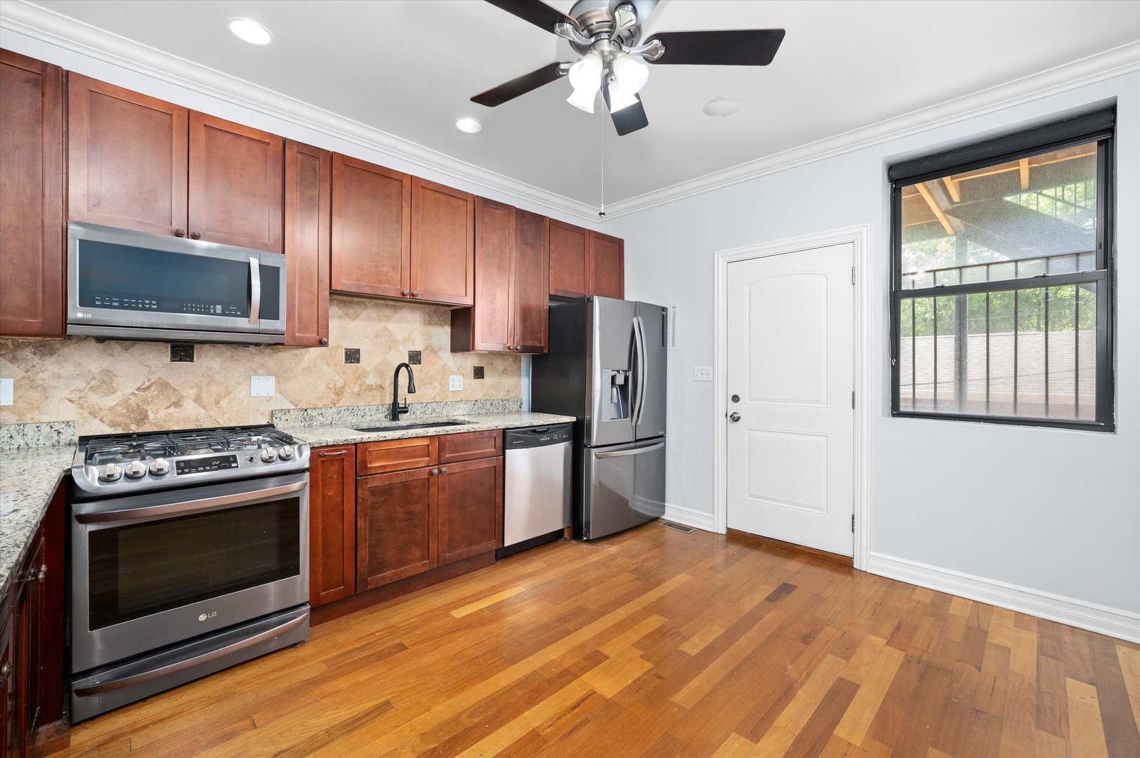 1363 East 64th Street, Unit 1 Chicago, IL 60637 - Photo 17 of 39 a kitchen with a stove a sink and a microwave