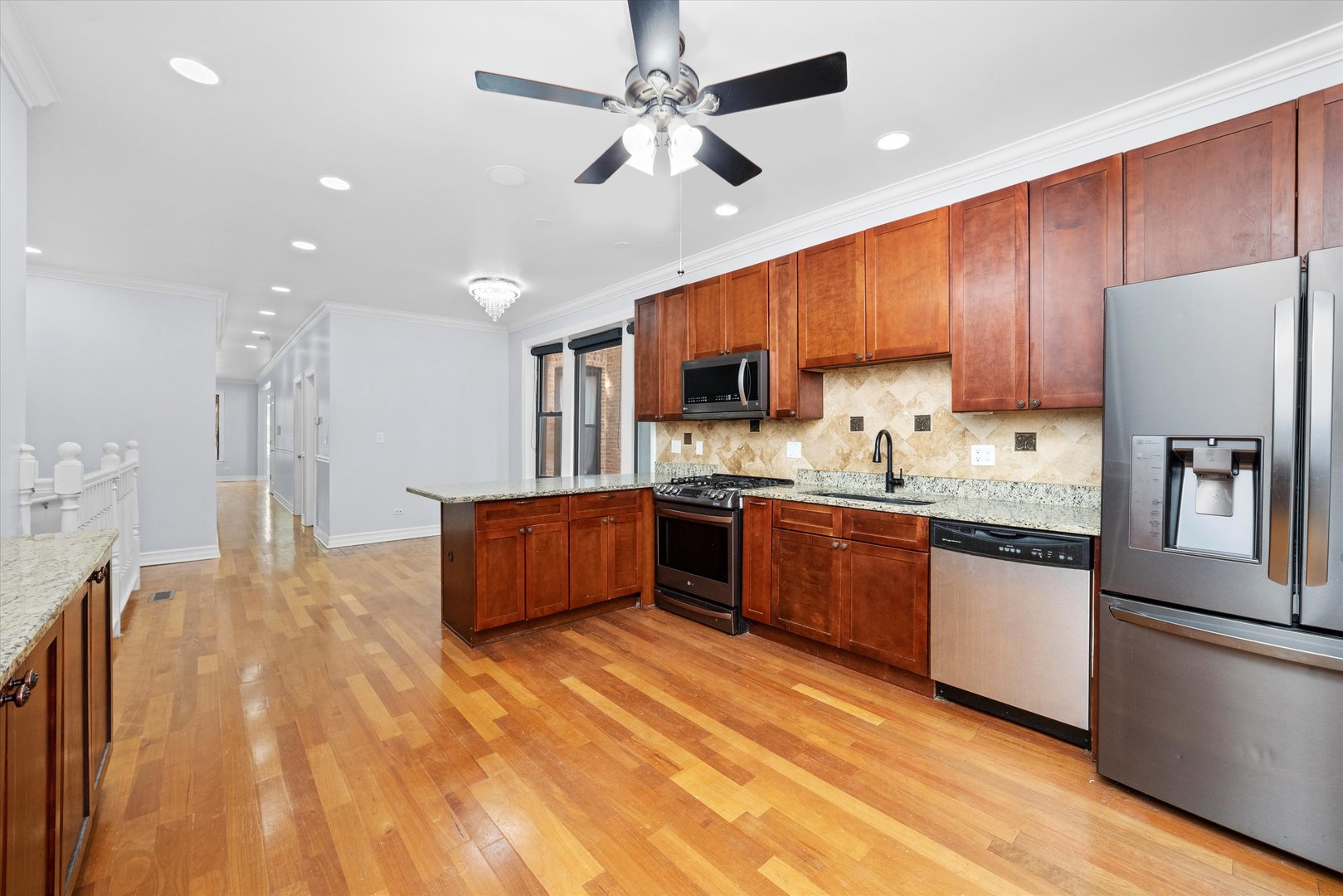 1363 East 64th Street, Unit 1 Chicago, IL 60637 - Photo 19 of 39 a kitchen with stainless steel appliances granite countertop a refrigerator a sink dishwasher a stove with wooden cabinets and floor