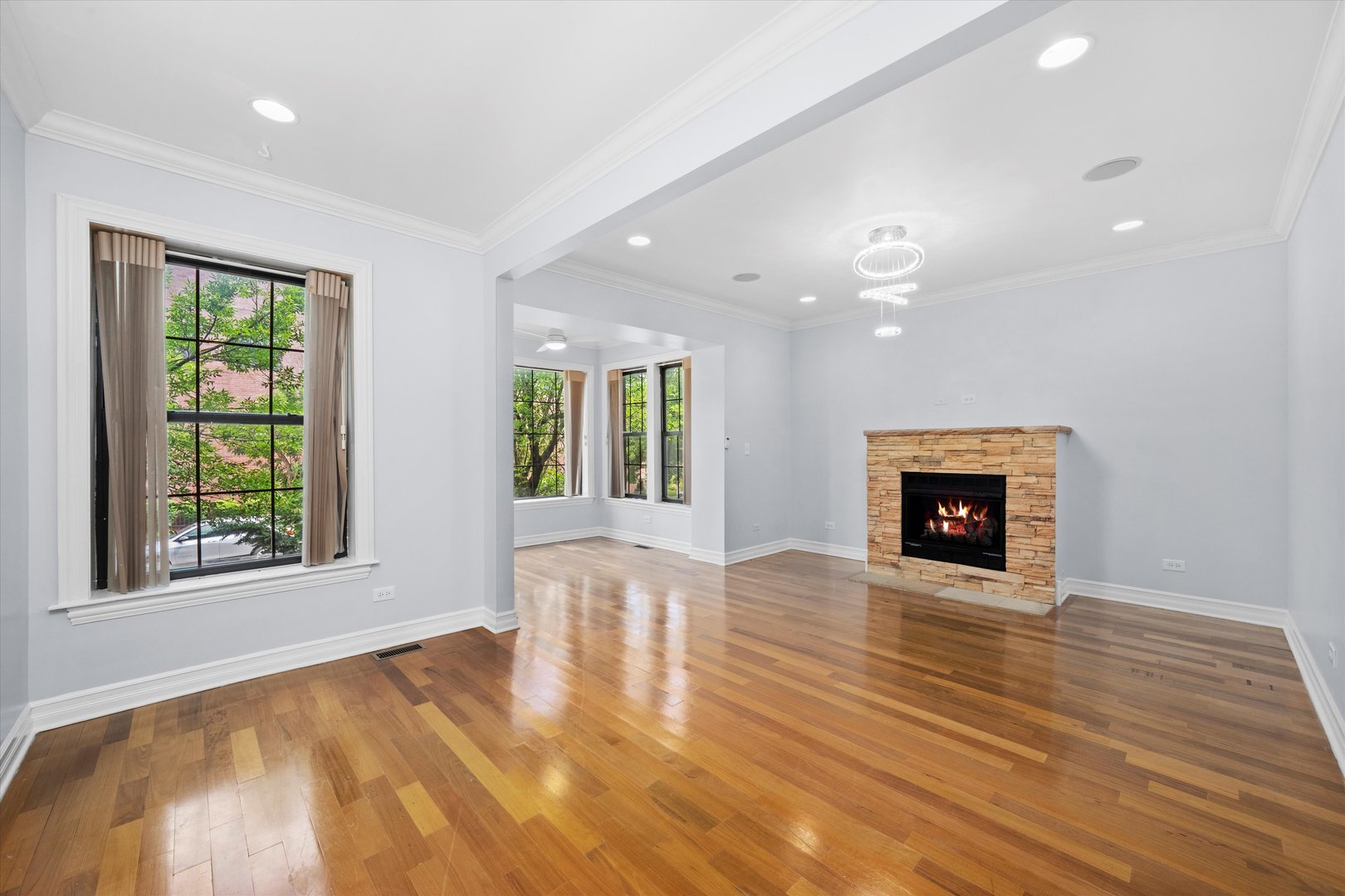 1363 East 64th Street, Unit 1 Chicago, IL 60637 - Photo 7 of 39 an empty room with wooden floor fireplace and windows