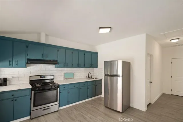 a kitchen with a refrigerator sink and wooden cabinets