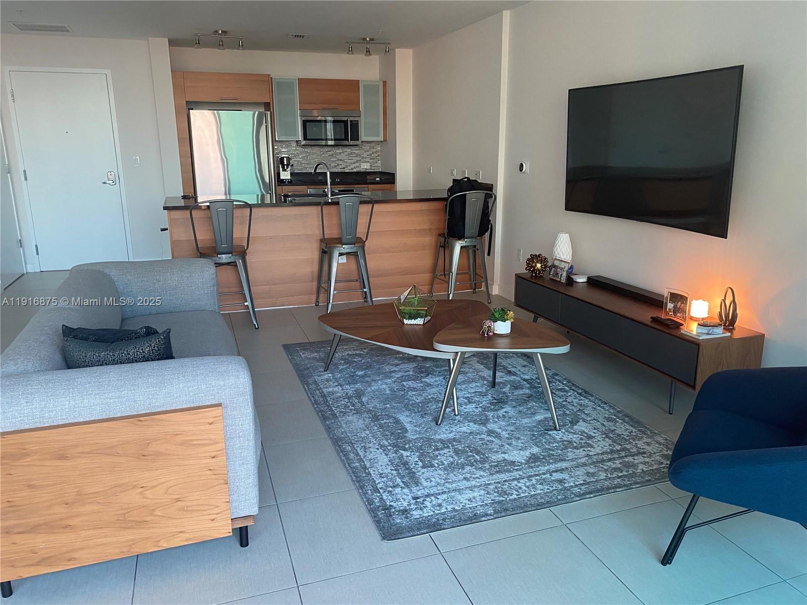 3301 Northeast 1st Avenue, Unit H2913 Miami, FL 33137 - Photo 2 of 11 a living room with furniture and a flat screen tv