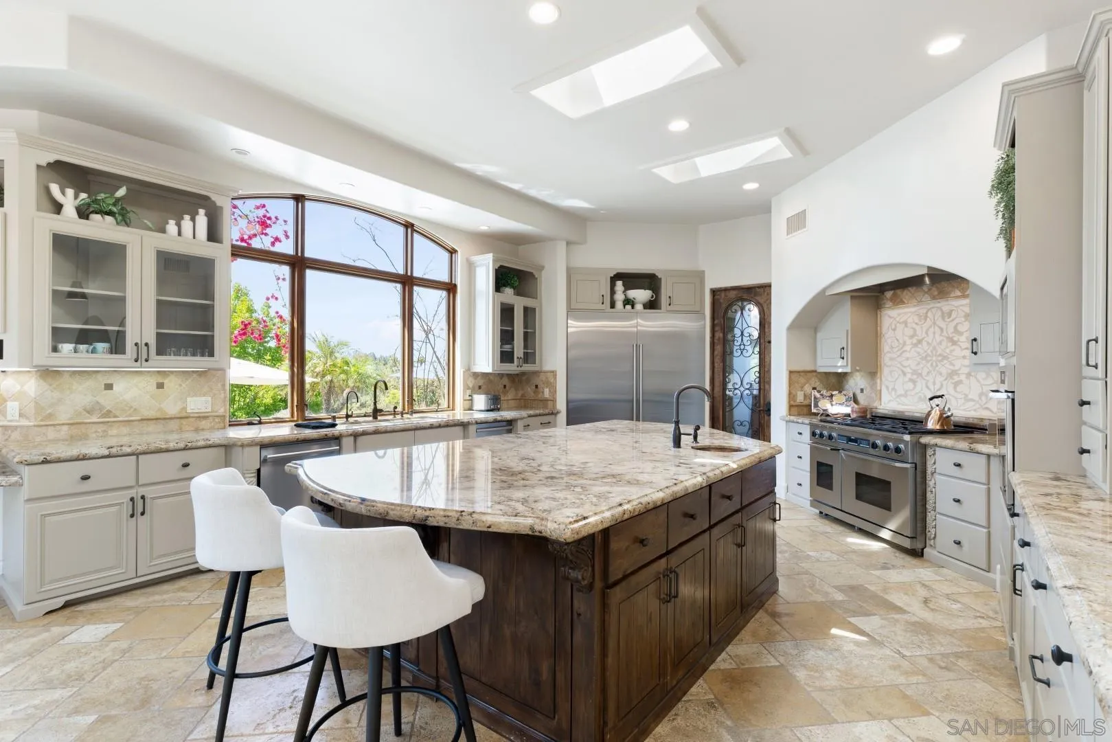 6089 Avenida Alteras Rancho Santa Fe, CA 92067 - Photo 6 of 23 a kitchen with kitchen island granite countertop a stove and a sink