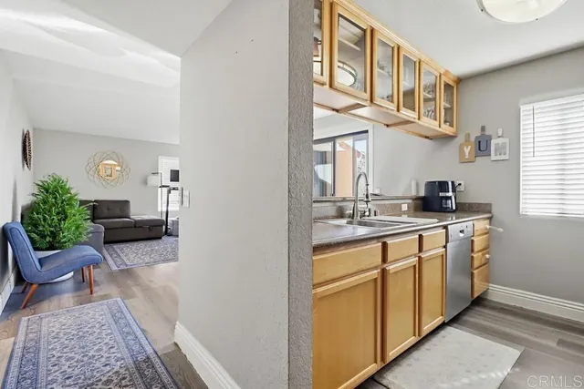 a view of living room kitchen with stainless steel appliances granite countertop furniture and a rug