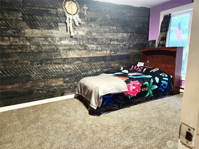 a bedroom with a bed a dresser and potted plants