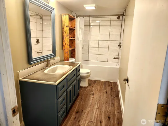 a bathroom with a granite countertop sink toilet and shower