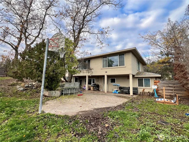 a front view of a house with garden and trees