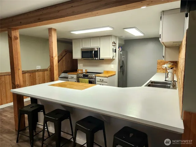 a kitchen with stainless steel appliances a table and chairs